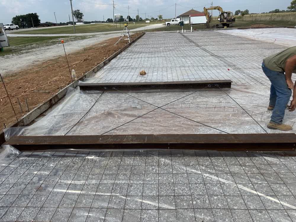 Formed concrete slab with rebar grid and vapor barrier laid out ready for a pour